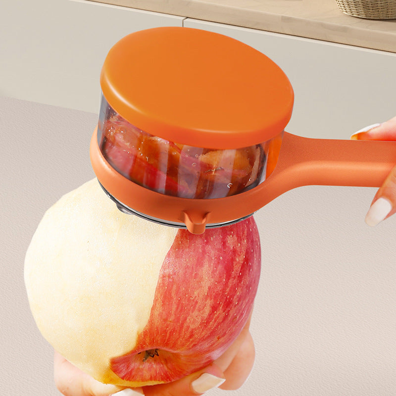 Orange apple peeler being used on a red apple with a neutral background