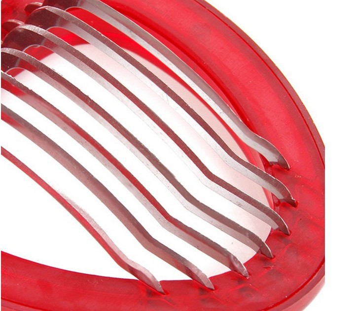 Red vegetable peeler with metal blades on a white background