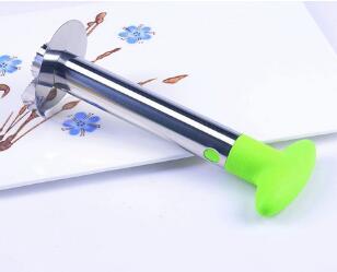 Metallic kitchen tool with green handle on a white background