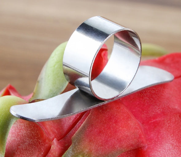 Metallic fruit peeler on a dragon fruit with a blurred background