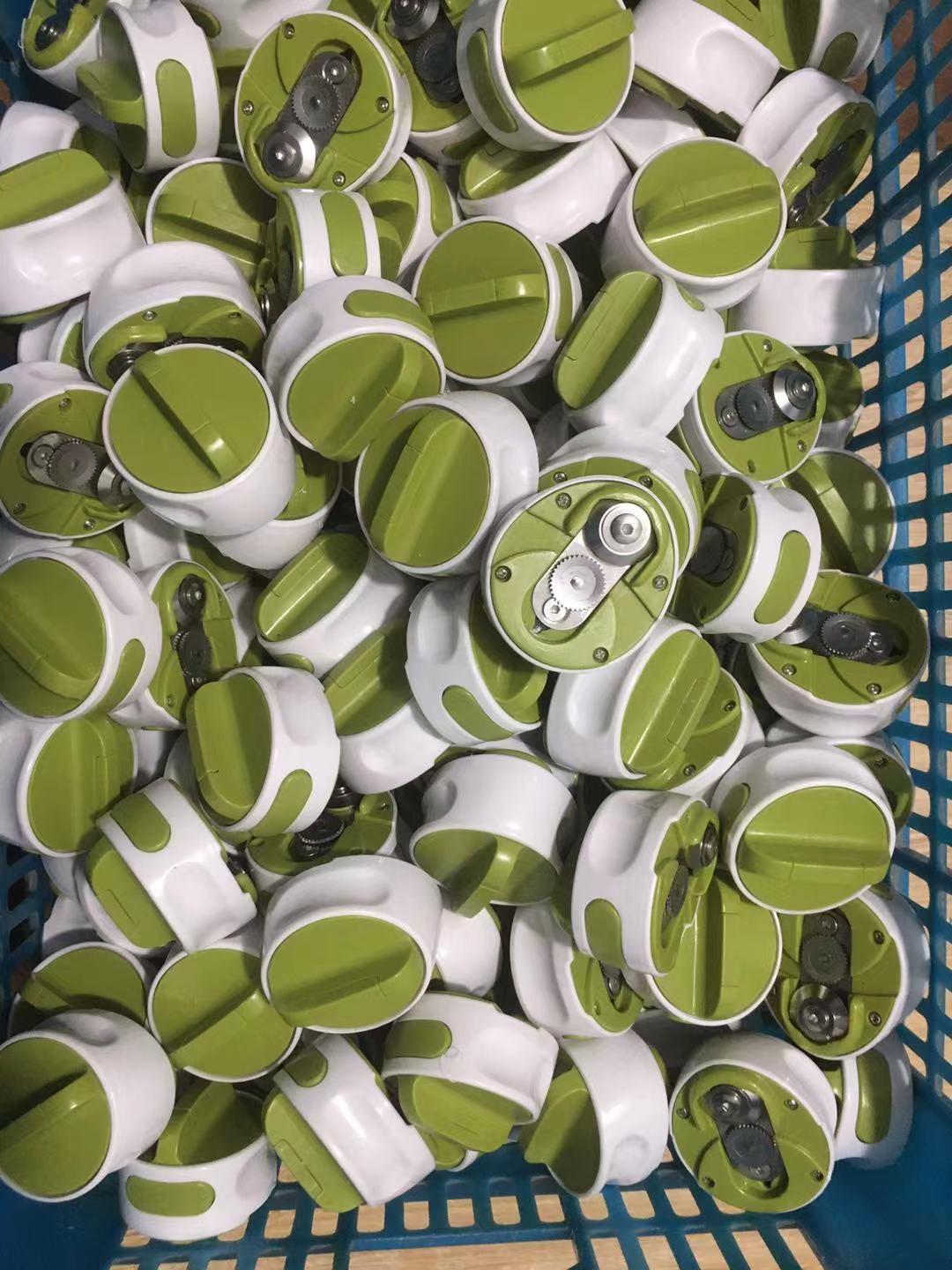 Pile of green and white cylindrical objects in a blue basket
